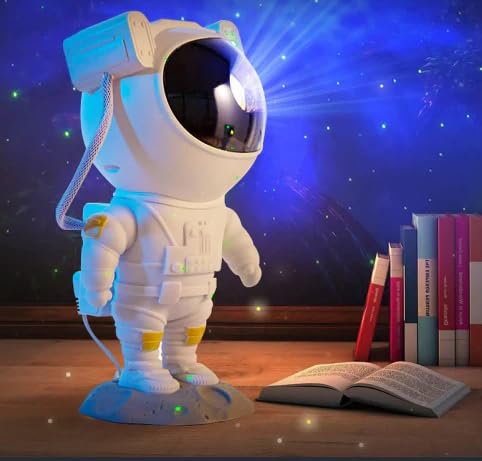 A toy astronaut with a lit helmet stands on a wooden surface. Nearby, an open book and stacked books are visible against a space-themed backdrop.